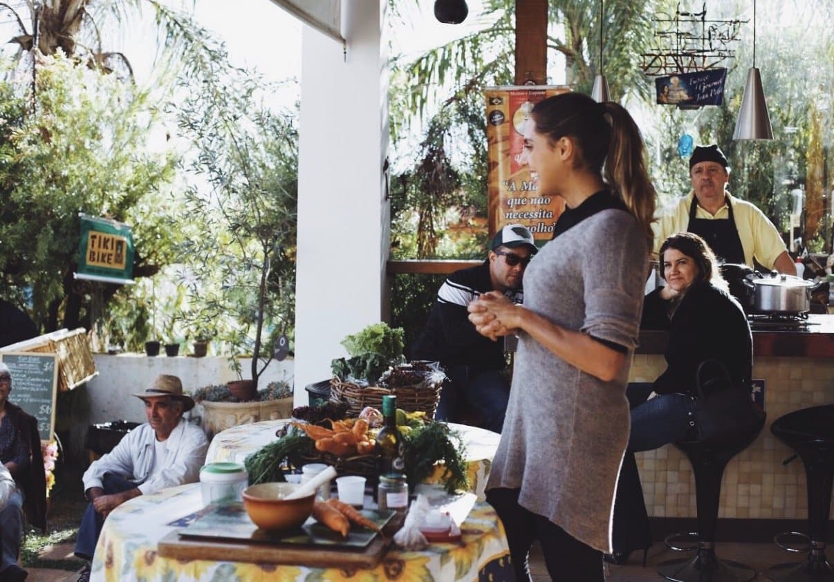 Xanda Fogaça em um encontro ao ar livre, diante de uma mesa de alimentos